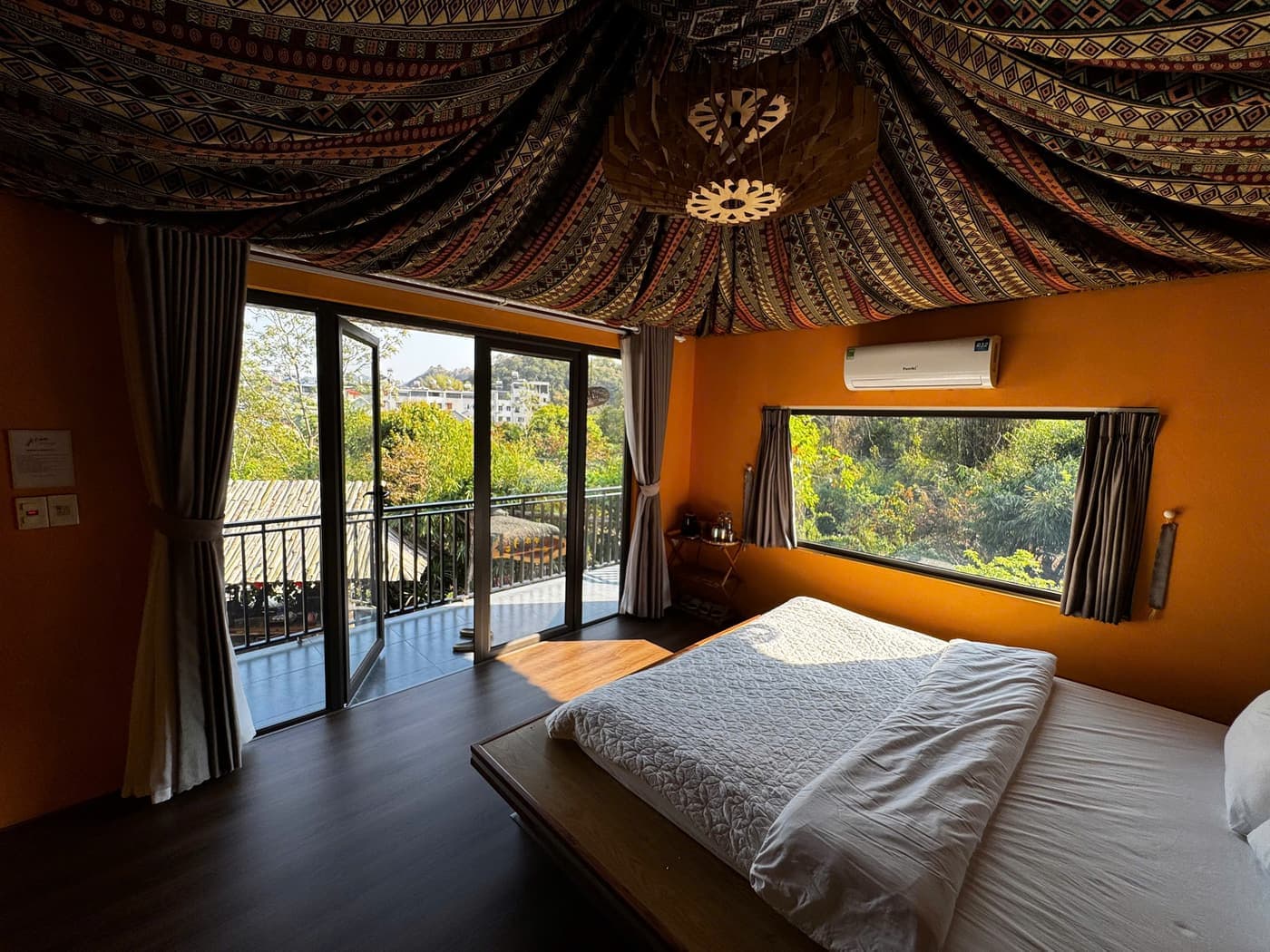 Phòng thổ cẩm 1 giường tại A Tủn Homestay: trần phủ vải thổ cẩm, tường cam, cửa ra ban công (1/3)