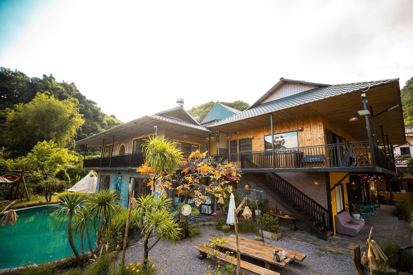 Ngoại cảnh A Tủn Homestay: nhà gỗ hai tầng, biển hiệu gỗ, sân đỗ xe (1/4)