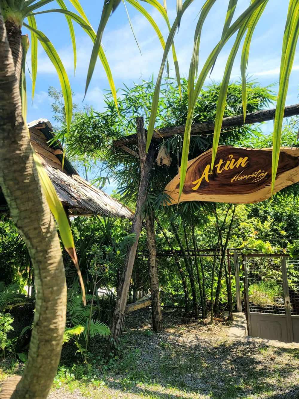 Ngoại cảnh A Tủn Homestay: nhà gỗ hai tầng, biển hiệu gỗ, sân đỗ xe (2/4)