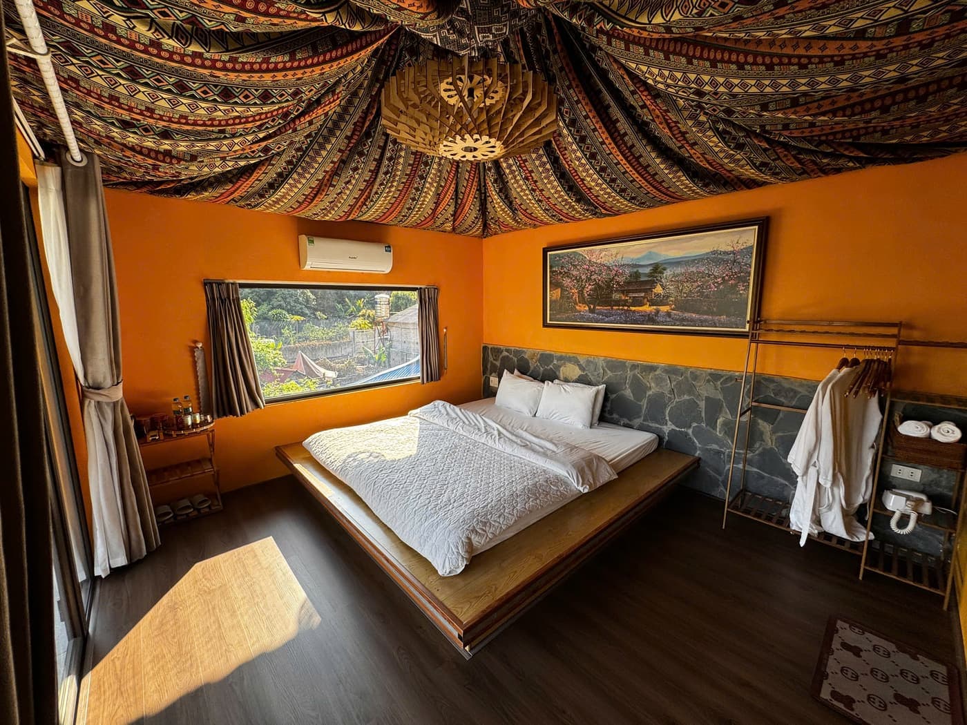 Phòng thổ cẩm 1 giường tại A Tủn Homestay: trần phủ vải thổ cẩm, tường cam, cửa ra ban công (2/3)