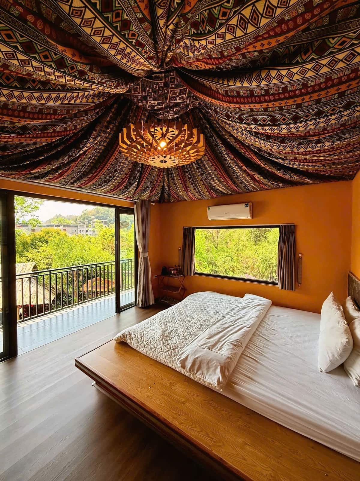 Phòng thổ cẩm 1 giường tại A Tủn Homestay: trần phủ vải thổ cẩm, tường cam, cửa ra ban công (3/3)